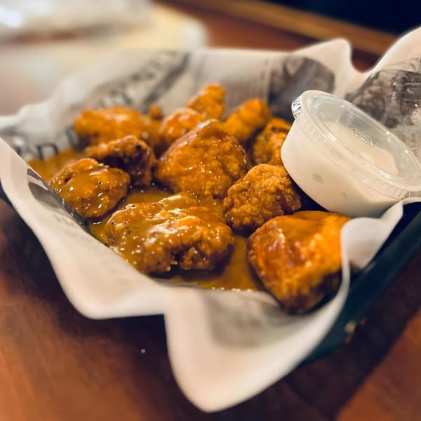 A basket of saucy boneless wings with a side of ranch dressing from Crawford's Corner Bar & Kitchen.